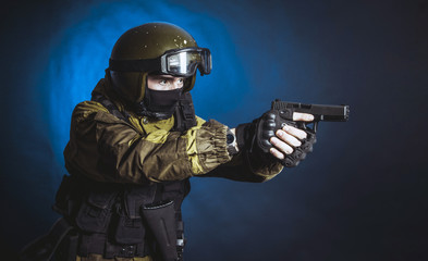 The man in the image of a member of the special forces division with two pistols in blue light. Russian police special force - Special Rapid Response Unit or SOBR (Spetsnaz).