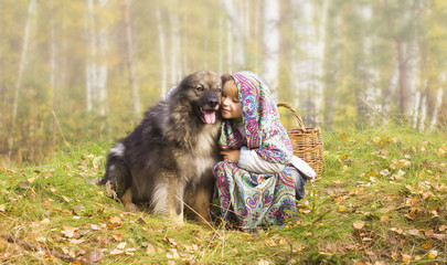 Маленькая девочка в платке сидит в туманном лесу с собакой © anejka7