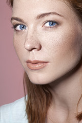Fototapeta na wymiar pretty red haired girl with blue eyes and freckles close up portrait 