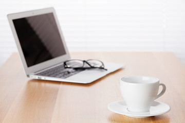 Office workplace with with laptop and coffee cup