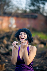 Woman in violet dress and black wig laughs