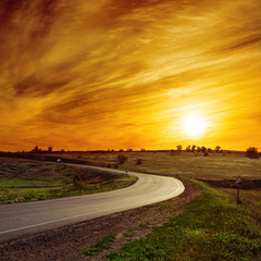 Obraz premium sun in orange sunset over asphalt road