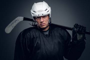 Hockey player holds gaming stick.