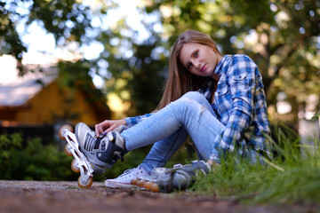 A woman putting on inline skates.