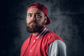 A man in hip hop clothes on a grey background.
