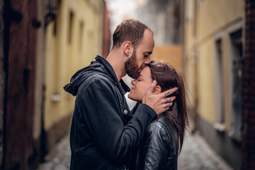 Positive bearded male kissing cute brunette female.