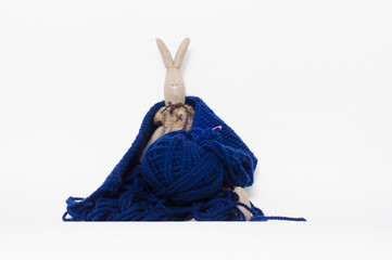 toy rabbit knits scarf made of blue yarn