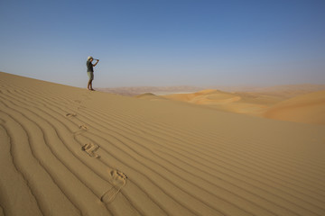 Man looking through spyglass in a desert