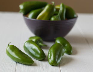 Green bell pepper in a bowl on a wooden table.