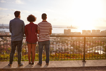 Three friends on a bridge looking out