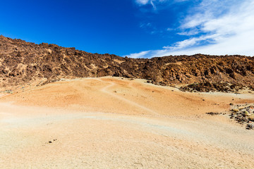 Fototapeta na wymiar Igneous landscape with mountain range on background, Teide National park, Tenerife, Spain