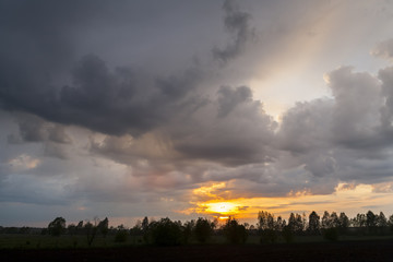 Fototapeta na wymiar Sunset on a background of storm clouds. Bad weather, rainy weather. 