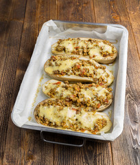 Baked zuchinni on a roasting pan on a wooden table.