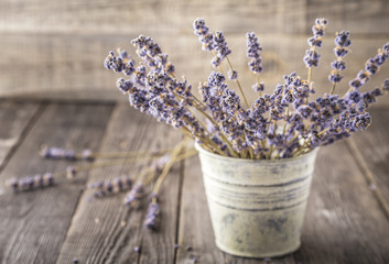 Dried lavender bunch on dark wooden table.