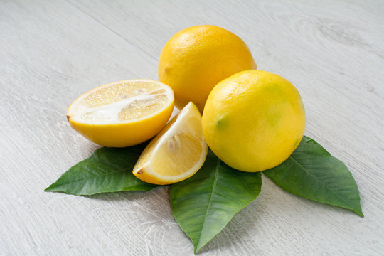 Fresh lemons with green leaf isolated on grey background