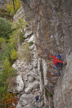 A man traditional rockclimbing the route Malpractice 10d, Skaha, BC