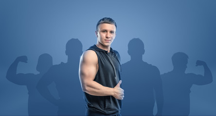Naklejka premium Young fitness man standing sideways and showing thumb up.