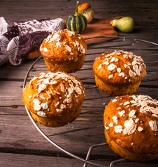 Healthy food - freshly baked pumpkin muffins with oatmeal, cool on a grid. In the rustic style