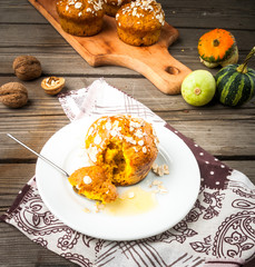 Healthy food - pumpkin muffins with oatmeal. On the rustic table,  surrounded by decorative pumpkins and nuts