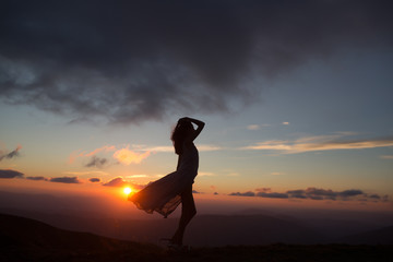 woman at sunset or sunrise in mountains