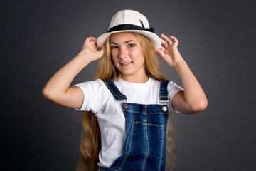 Naklejka premium Cute teenage girl in hat on a grey background 