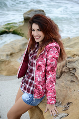 beautiful girl with colorful windbreaker by the sea