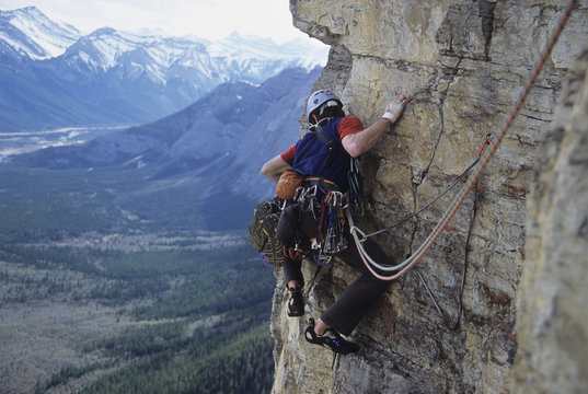 A young male climber traversing, Yamnuska, Alberta, Canada.