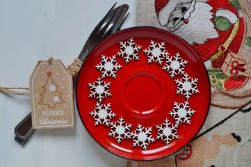 Christmas time table setting with silverware on red plate - festive table
