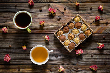 Sweet food pattern. Box of chocolate truffles, coffee beans, dry rose flowers, cup of black coffee...