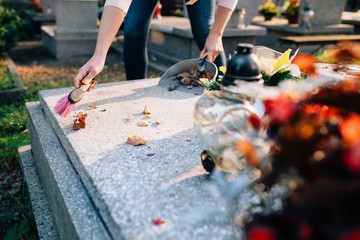 A woman cleans the grave