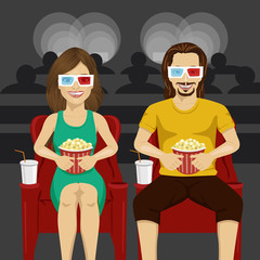 Happy couple sitting in movie theater watching 3D movie, eating popcorn, smiling.