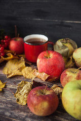 Naklejka na ściany i meble Hot tea cup on an autumn day. Table background with leaves and a