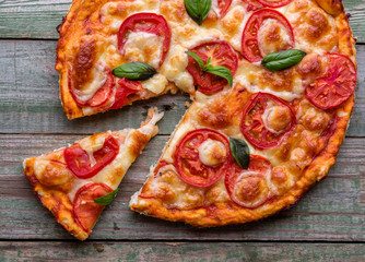 Slice of pizza with cheese on rustic wood table