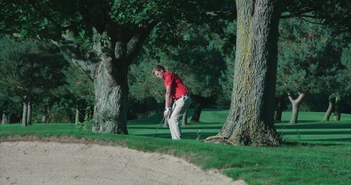 Golfer hits ball out of the rough towards camera