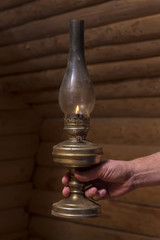 hand holds the old oil lamp in the dark
