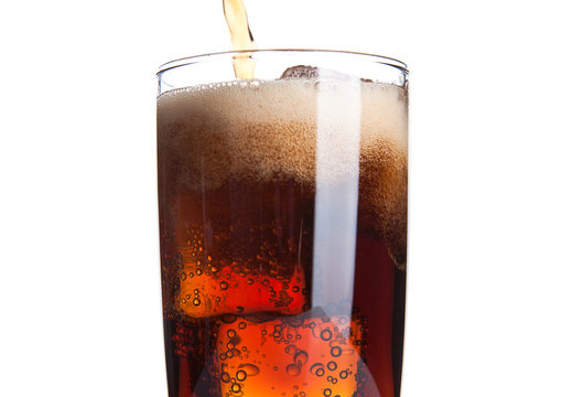 Cola glass with ice cubes and bubbles on white