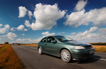 Fototapeta premium Car on road through countryside