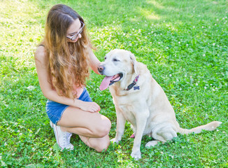 Girl playing with her labrador retriever dog in the park