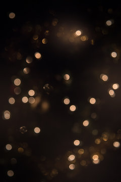Glitter vintage lights background. dark gold and black. defocused