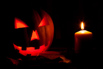 Calabaza de Halloween junto a una vela encendida