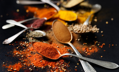 Various spices and herbs on black background 
