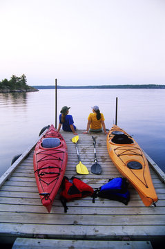 Kayakers relaxing on Nutimik Lake campground boat dock, Whiteshell Provincial Park, Manitoba, Canada.
