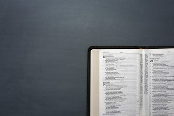 An Opened Bible on a Dark Chalkboard Surface