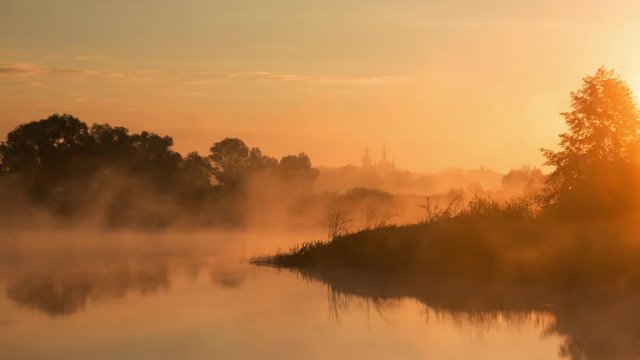 time lapse of Sunrise over river, landscape, fog running over the river, church on the background