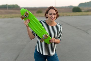 Cheerful young girl with a skateboard in hands. © dibas99