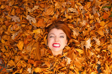 Young lady covered by leaves.