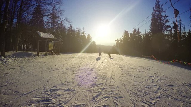 K footage of mother and son skiing down from a slope on a sunny afternoon