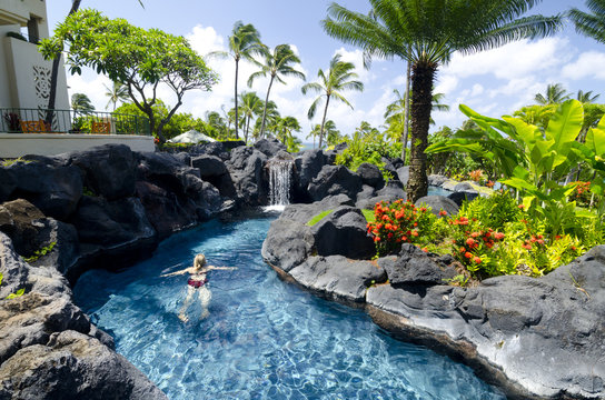 A woman relaxes in the swimming pool at the Grand Hyatt Hotel, Kaua'i