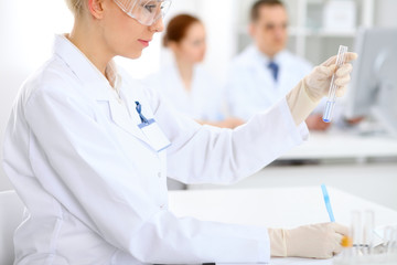 Scientific research team with clear solution in laboratory