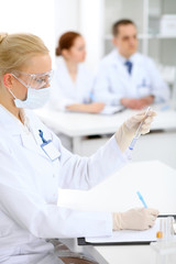 Scientific research team with clear solution in laboratory